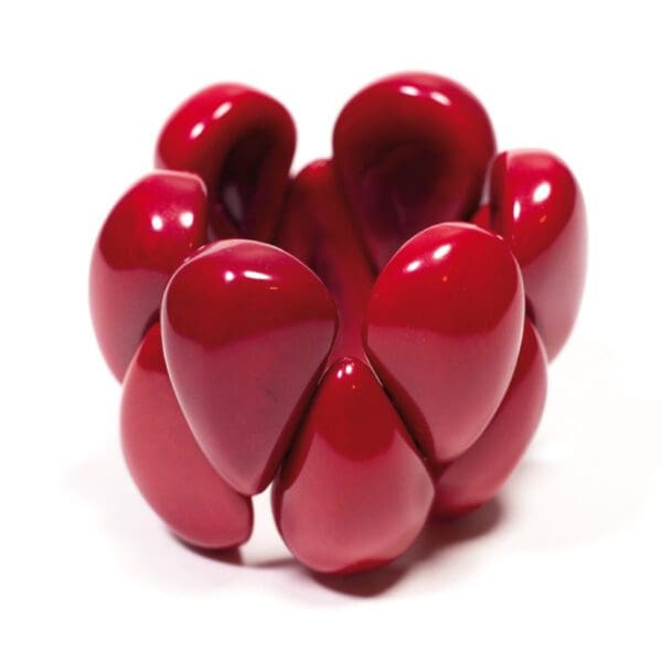 A red Tagua Raindrop Bracelet is shown in the image