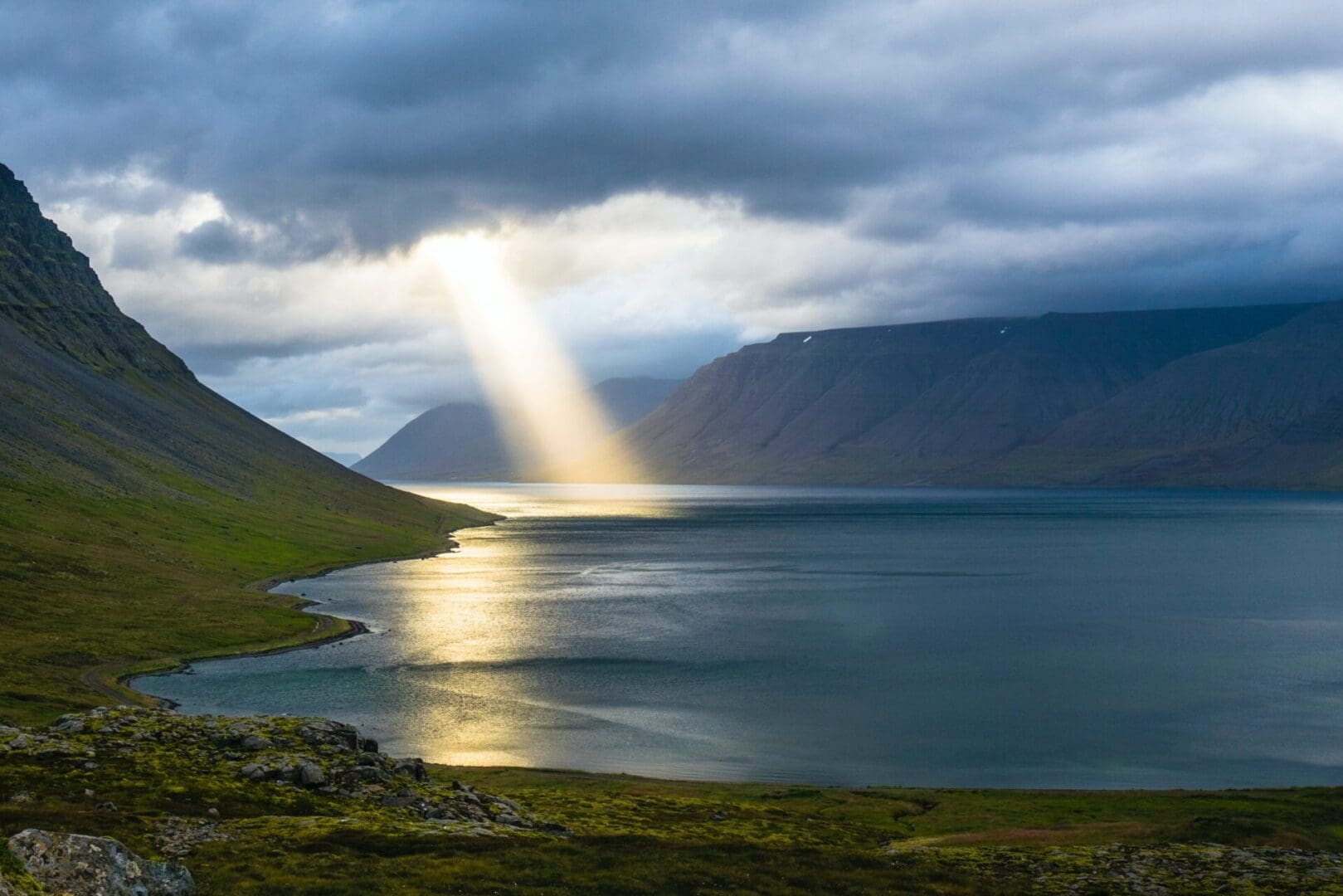 A body of water with mountains in the background