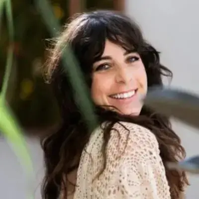 A woman smiling for the camera with long hair.